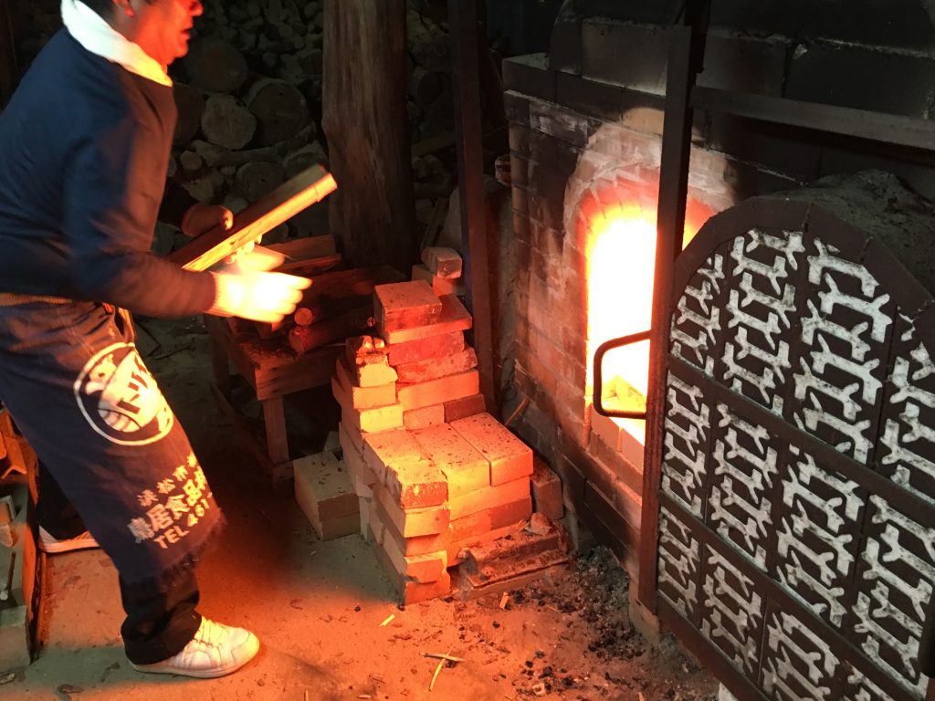 窯に薪を焼べる様子